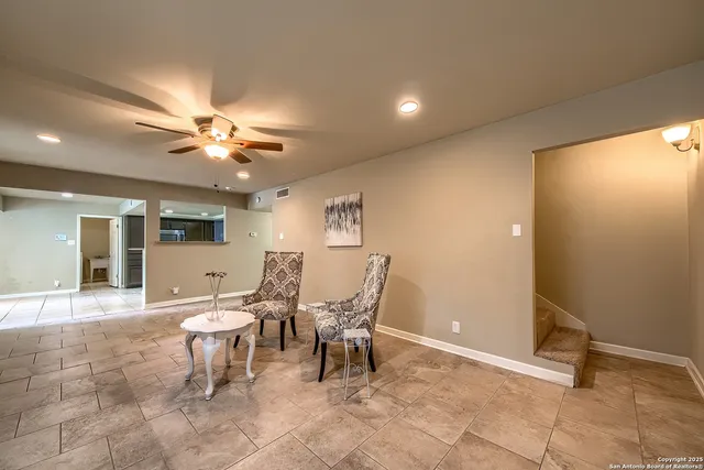 a view of a dining room with furniture and chandelier fan