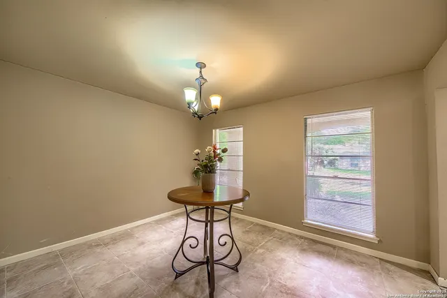 a view of a room with a chandelier fan and wooden floor