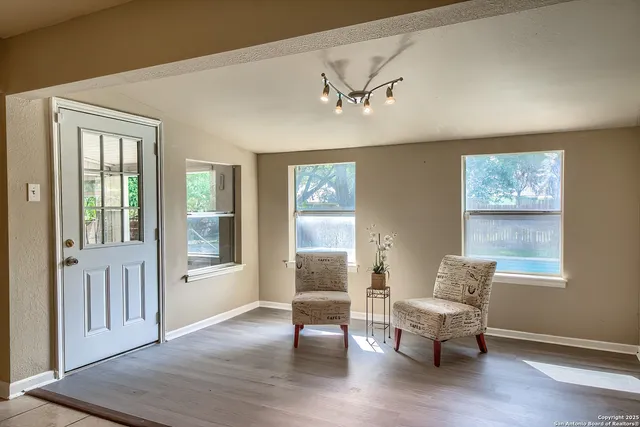 a living room with furniture and two window