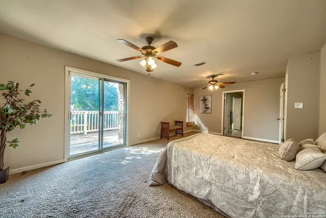 a spacious bedroom with a bed and a chandelier