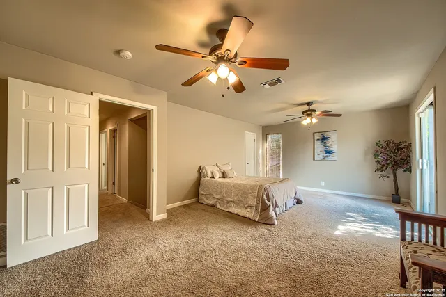 a living room with furniture and a chandelier fan