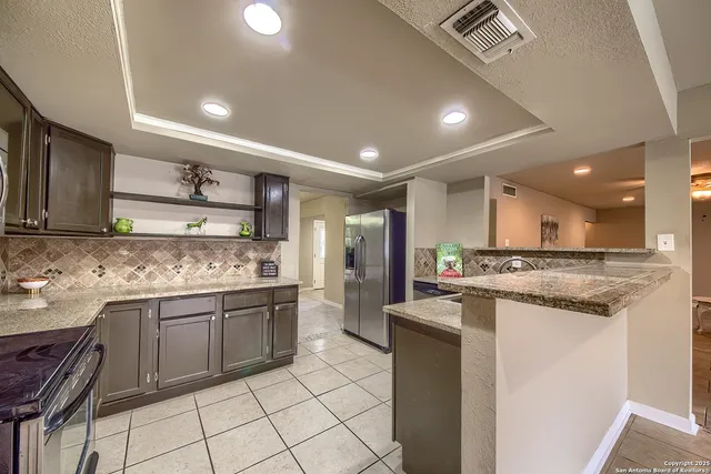 a kitchen with stainless steel appliances granite countertop a sink and cabinets