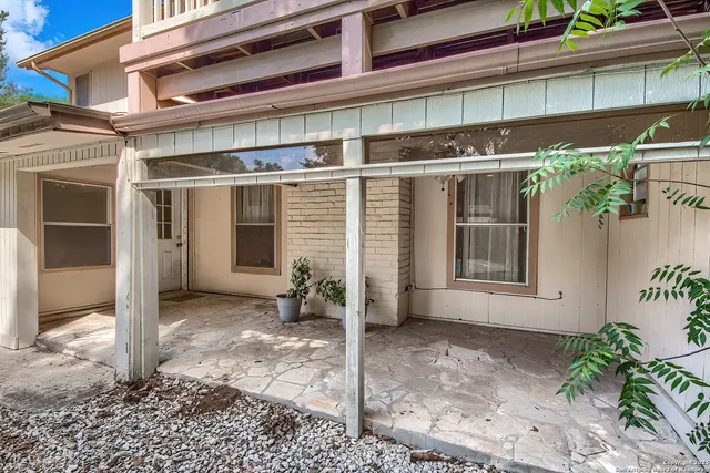 a view of a house with a door and wooden bench