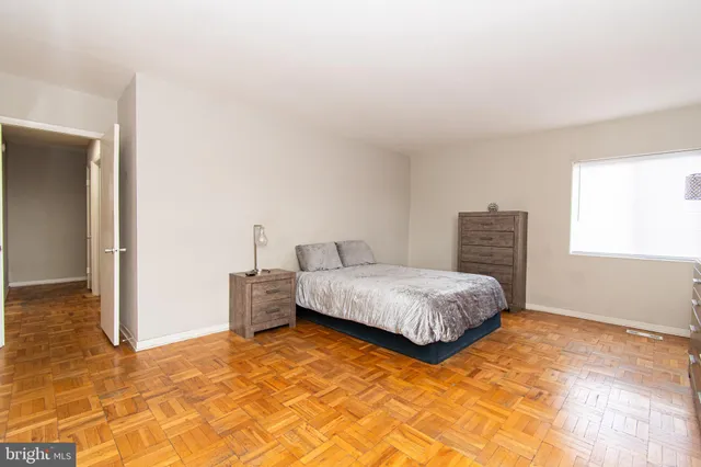 a bedroom with a bed and wooden floor