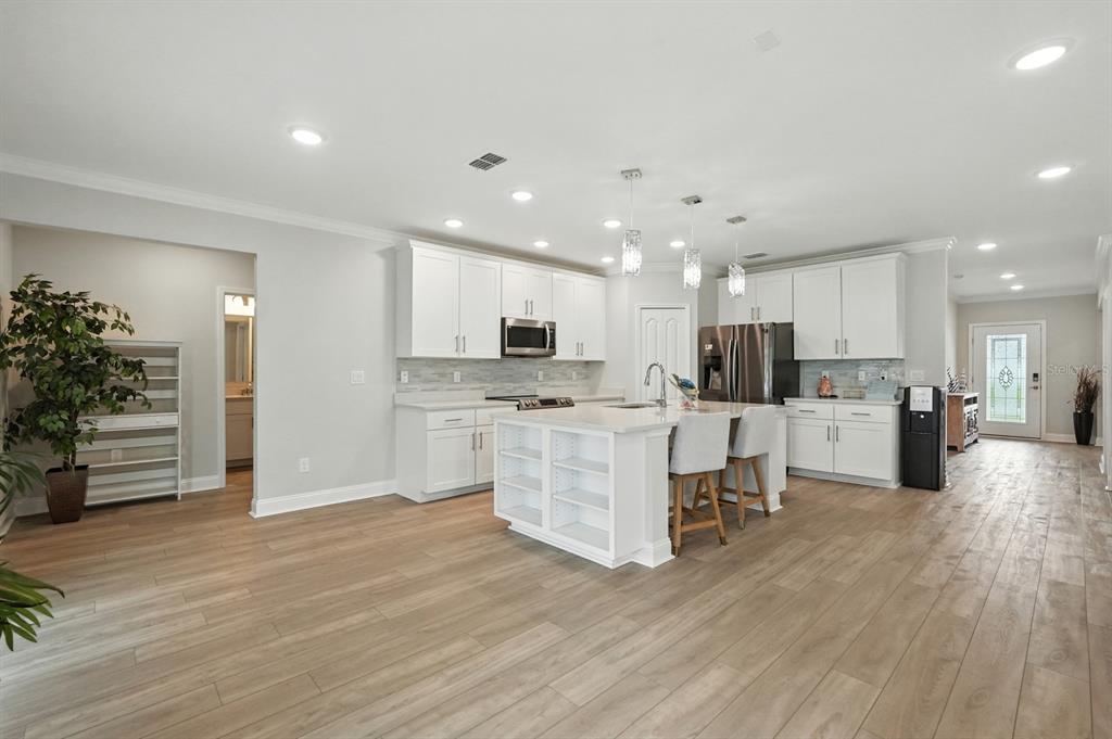 28 Ridge Road Palm Coast, FL 32137 - Photo 11 of 57 a kitchen with white cabinets and stainless steel appliances
