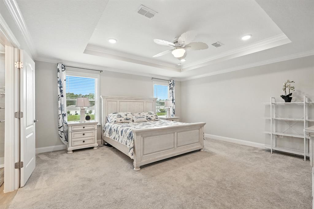 28 Ridge Road Palm Coast, FL 32137 - Photo 29 of 57 a spacious bedroom with a bed and a chandelier