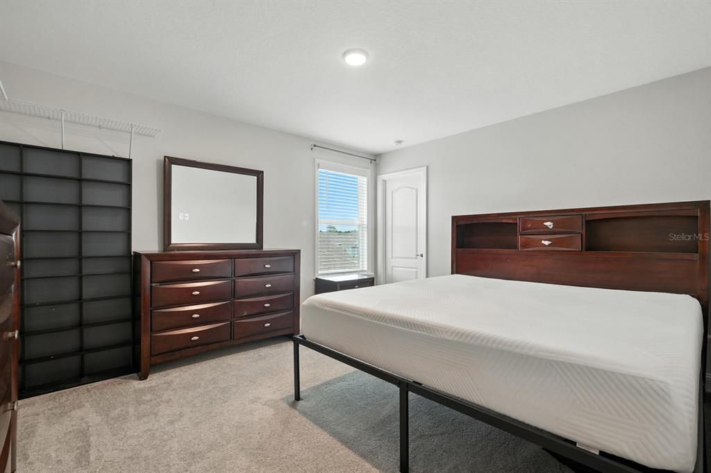 28 Ridge Road Palm Coast, FL 32137 - Photo 36 of 57 a bedroom with a bed and a dresser