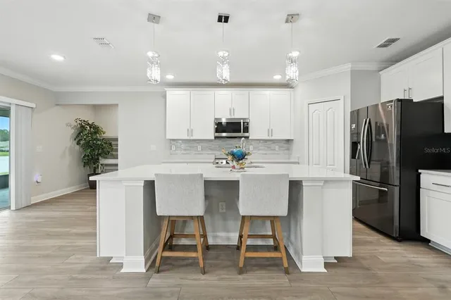 a living room with furniture a flat screen tv and a floor to ceiling window