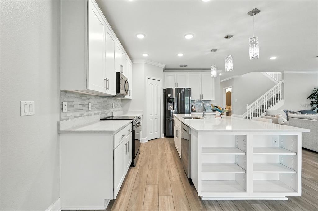28 Ridge Road Palm Coast, FL 32137 - Photo 10 of 57 a view of a kitchen with kitchen island a sink stainless steel appliances and cabinets