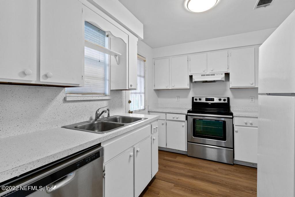 1647 El Camino Road, Unit 5 Jacksonville, FL 32216 - Photo 14 of 44 a kitchen with white cabinets and appliances