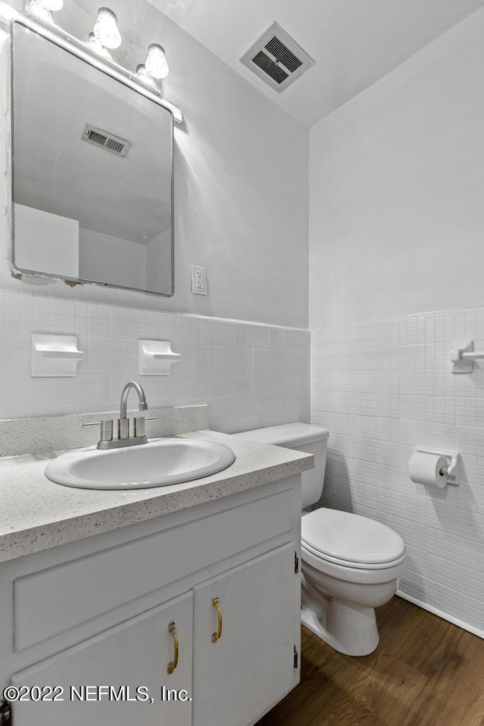 1647 El Camino Road, Unit 5 Jacksonville, FL 32216 - Photo 28 of 44 a bathroom with a toilet a sink and mirror