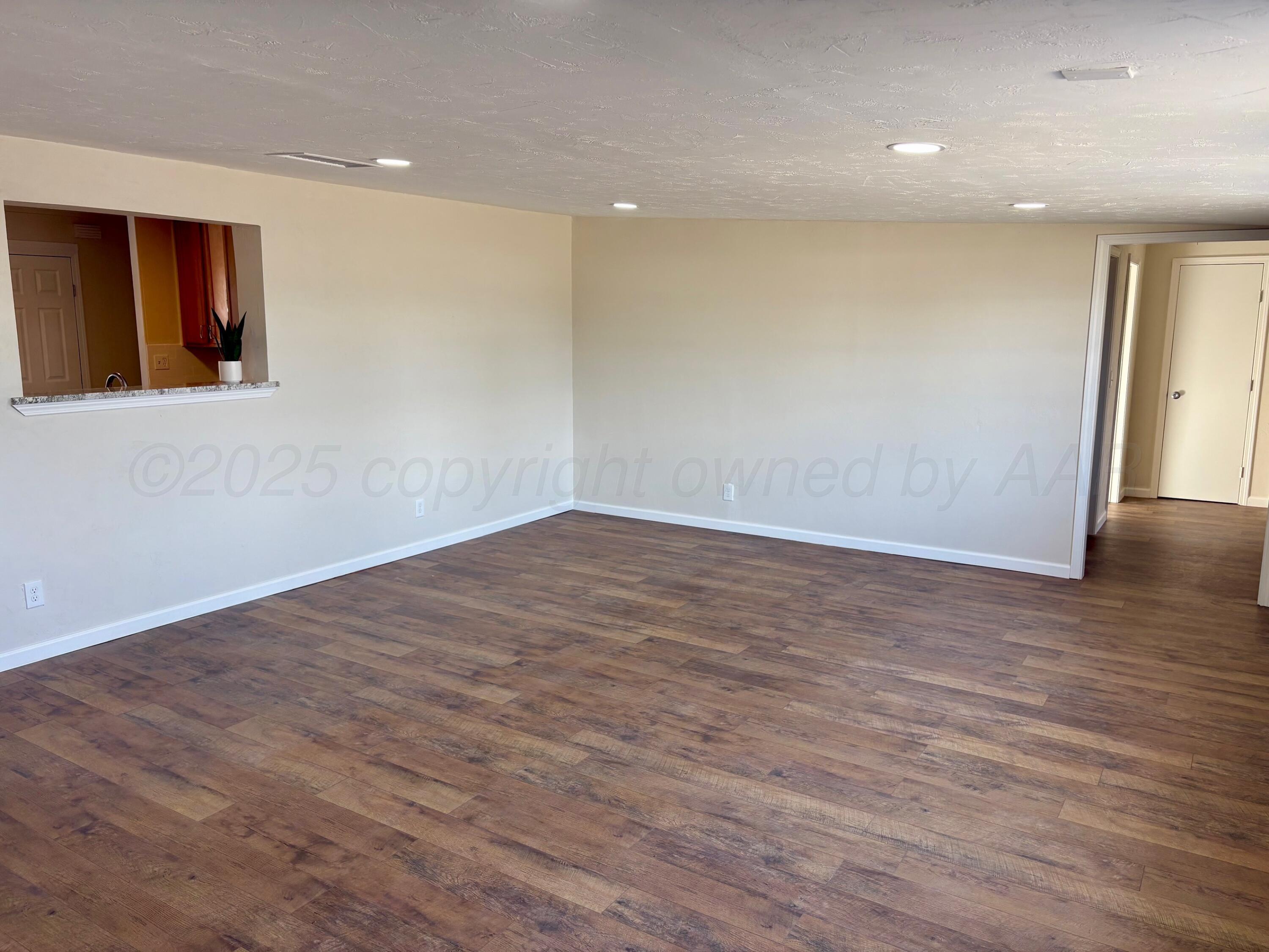 1114 Parr Street Amarillo, TX 79106 - Photo 11 of 28 an empty room with wooden floor and window