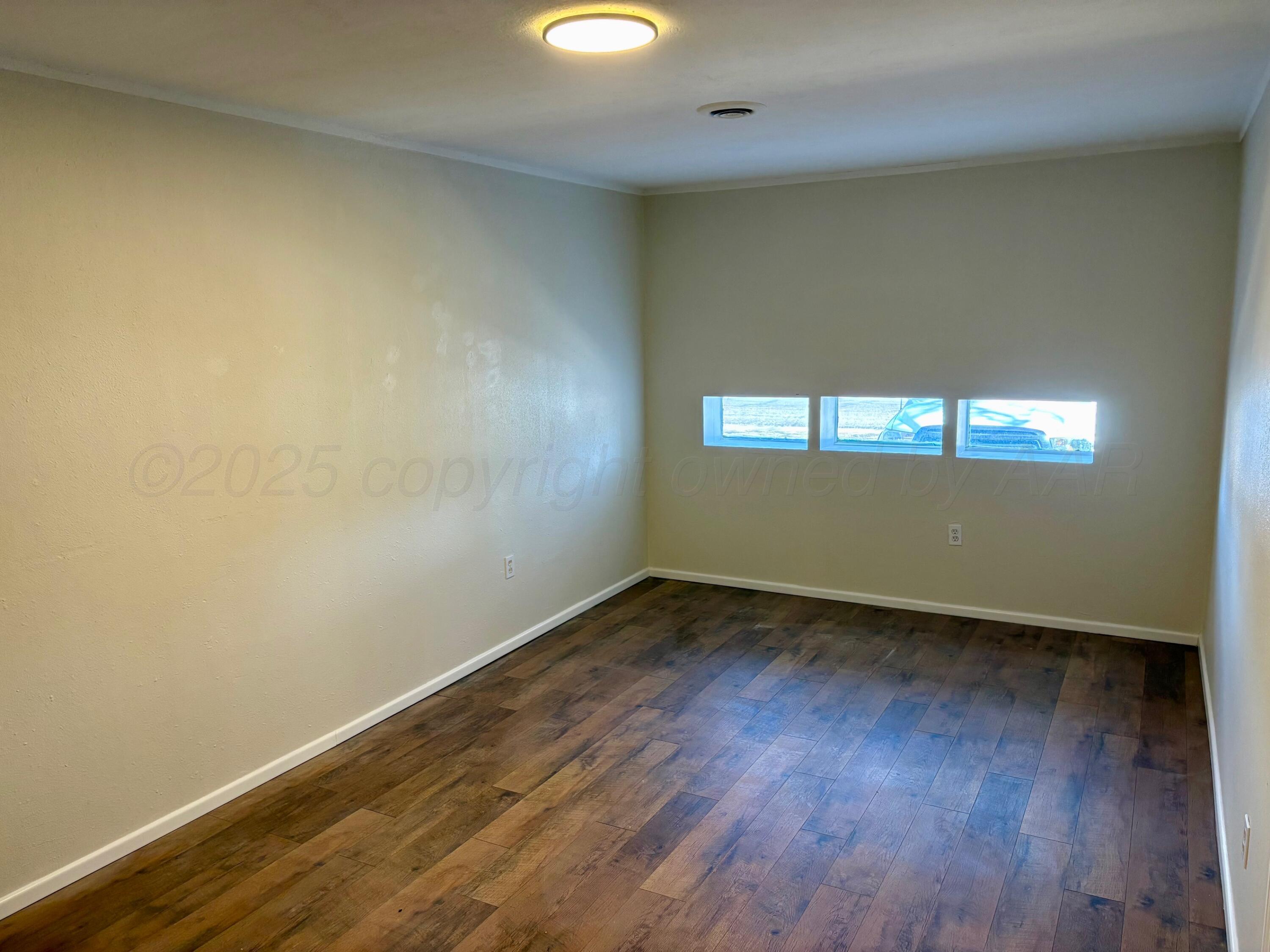 1114 Parr Street Amarillo, TX 79106 - Photo 12 of 28 an empty room with wooden floor and windows