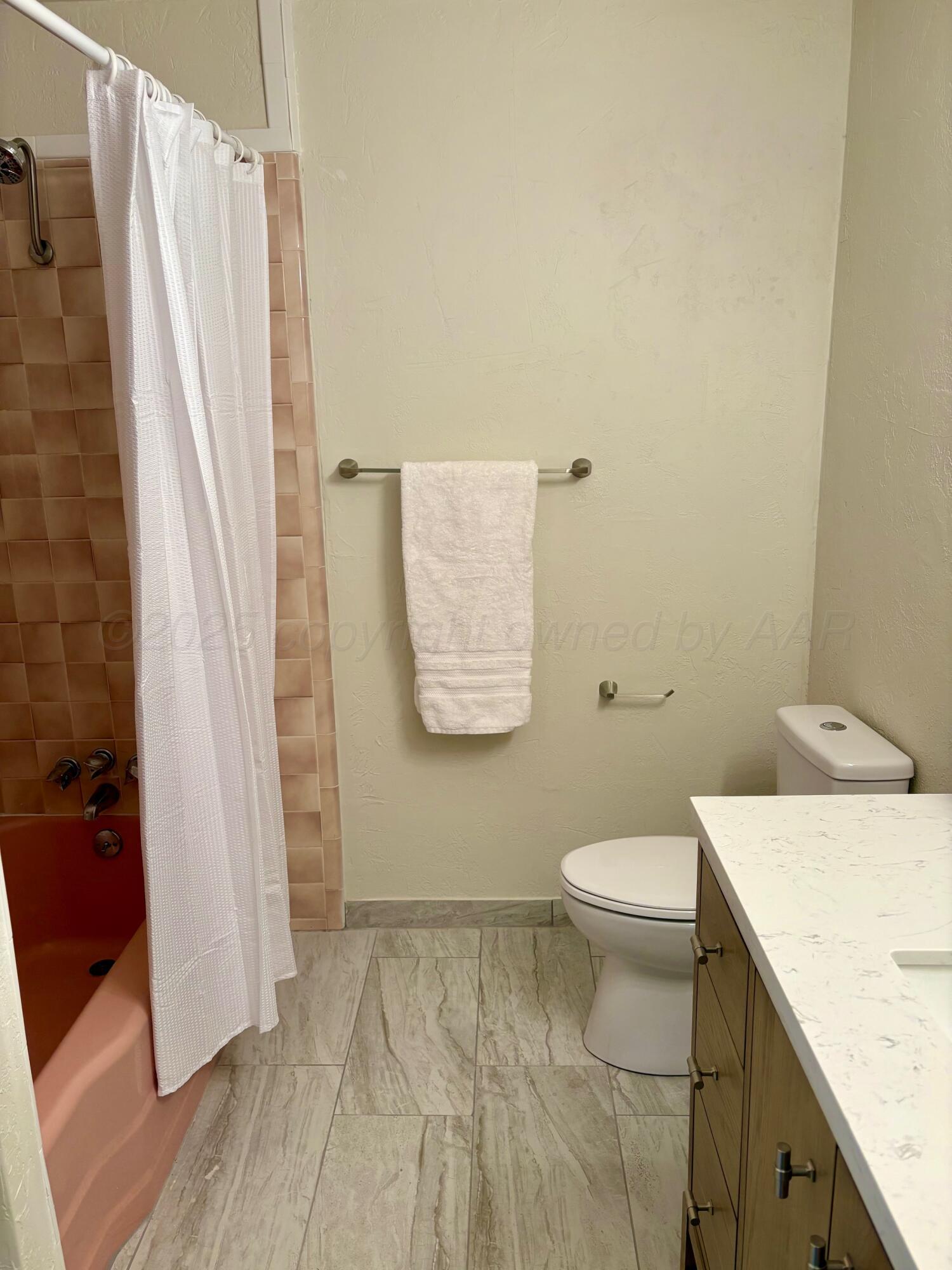 1114 Parr Street Amarillo, TX 79106 - Photo 19 of 28 a white toilet sitting next to a shower curtain