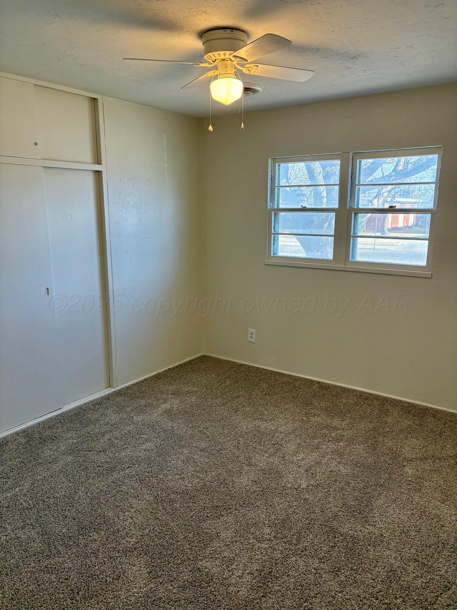 1114 Parr Street Amarillo, TX 79106 - Photo 20 of 28 an empty room with chandelier fan and windows