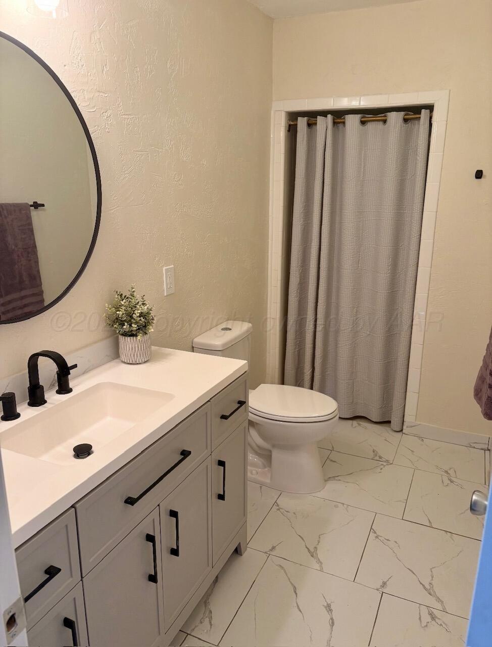 1114 Parr Street Amarillo, TX 79106 - Photo 24 of 28 a bathroom with a sink a toilet and a mirror