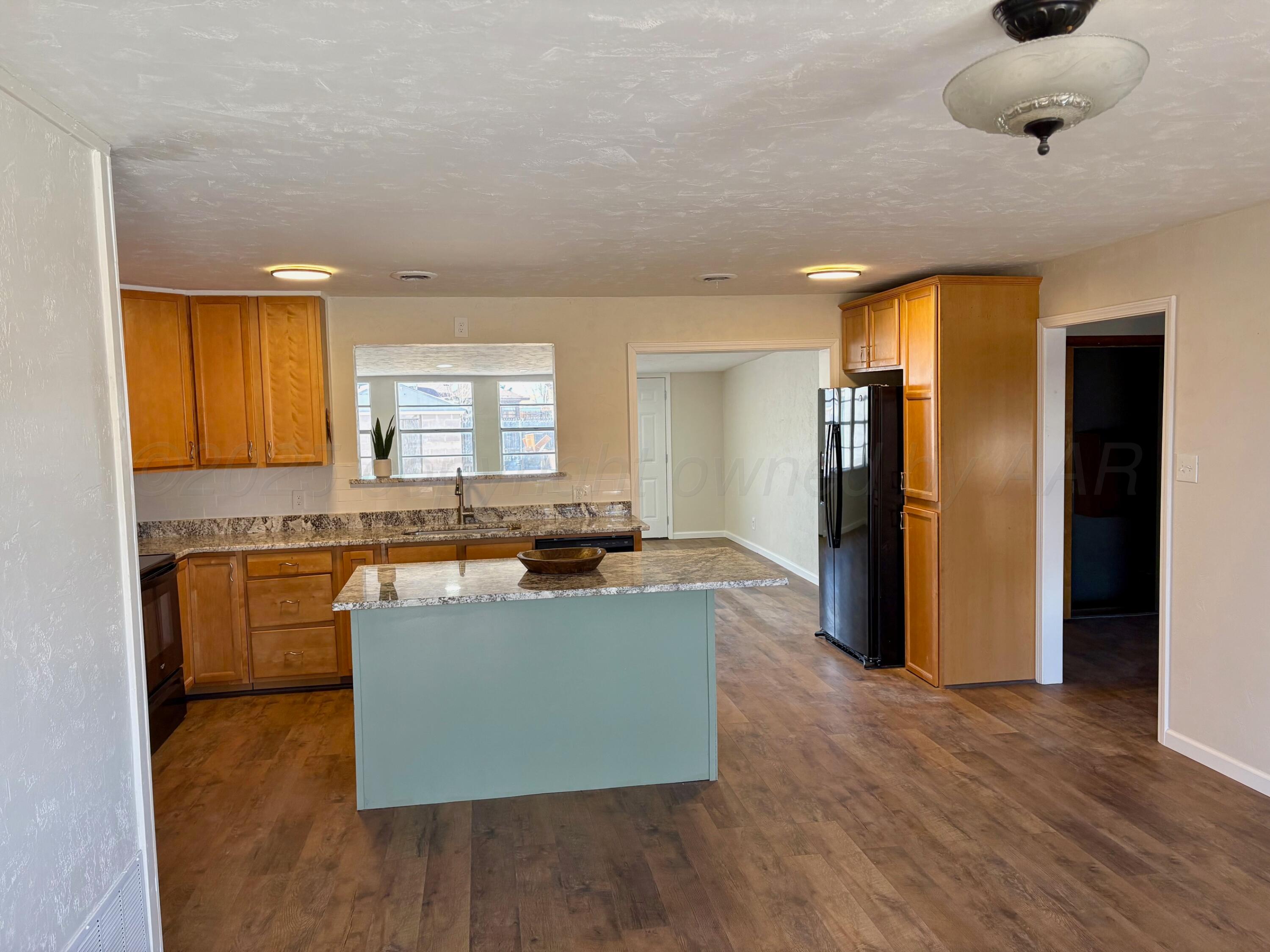 1114 Parr Street Amarillo, TX 79106 - Photo 5 of 28 a kitchen with stainless steel appliances granite countertop a refrigerator a sink dishwasher a stove and a dining table with wooden floor