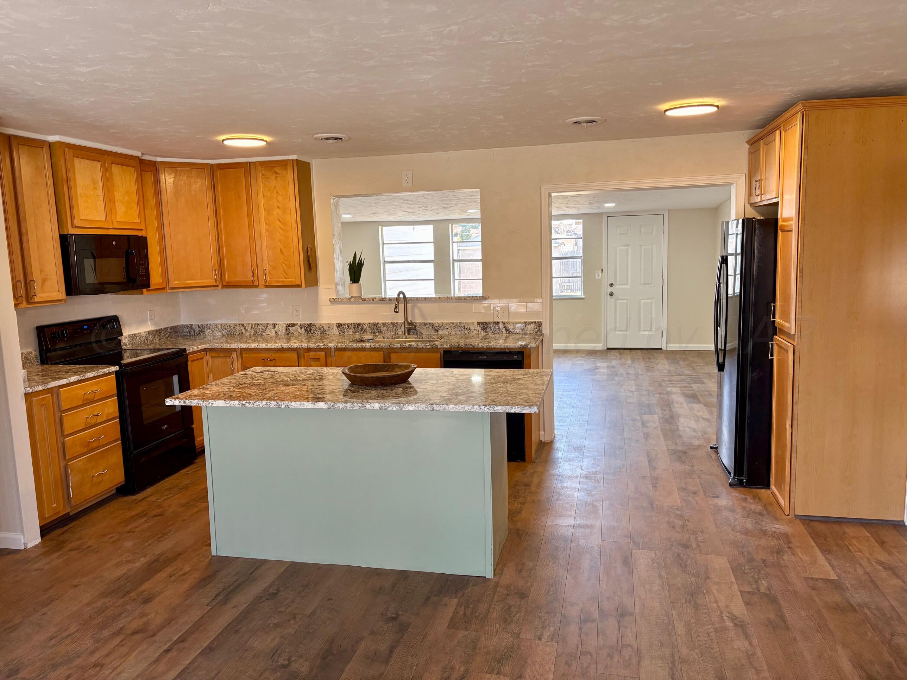 1114 Parr Street Amarillo, TX 79106 - Photo 6 of 28 a large kitchen with stainless steel appliances granite countertop a stove a sink and a refrigerator