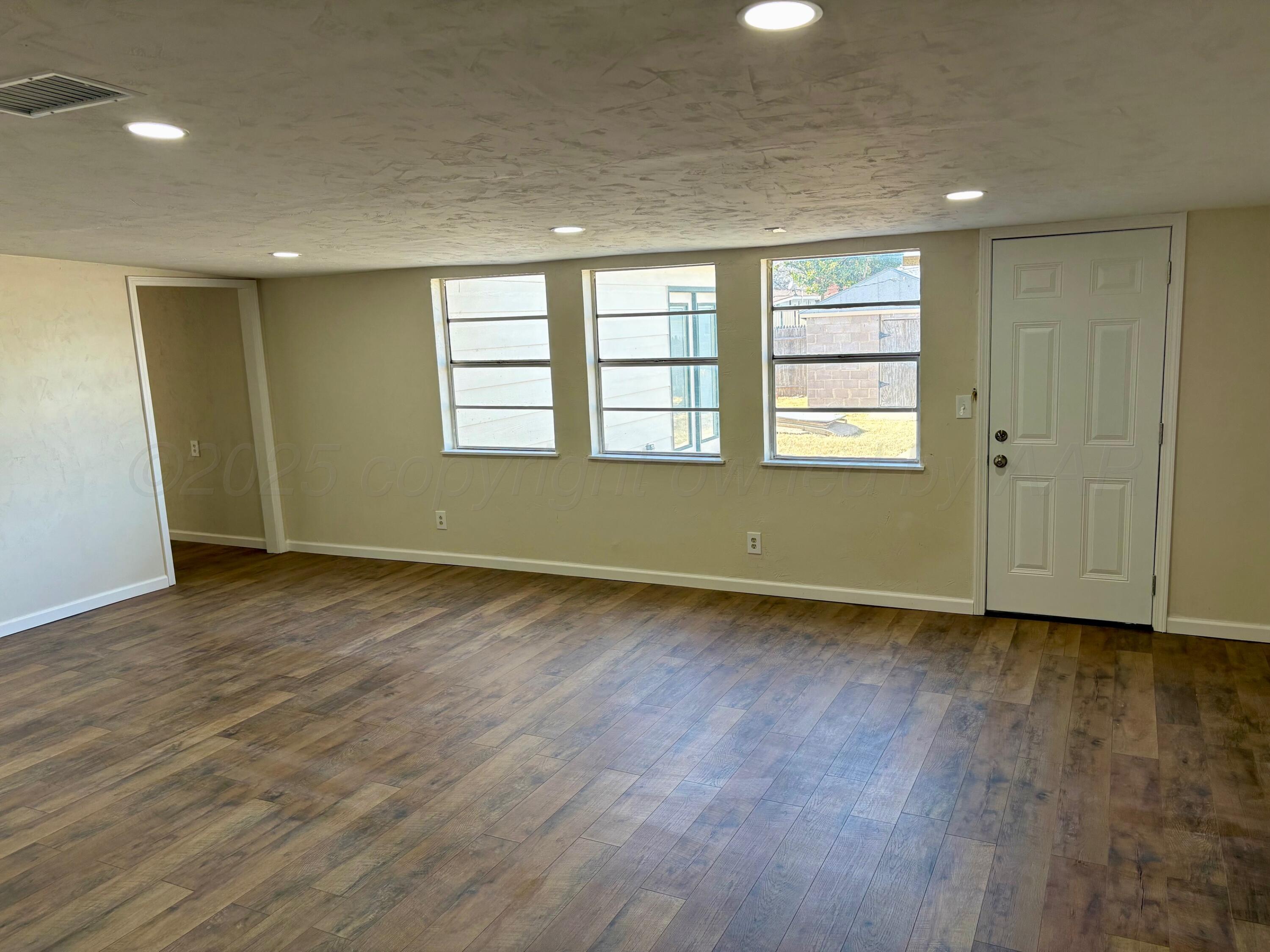 1114 Parr Street Amarillo, TX 79106 - Photo 9 of 28 an empty room with wooden floor and windows