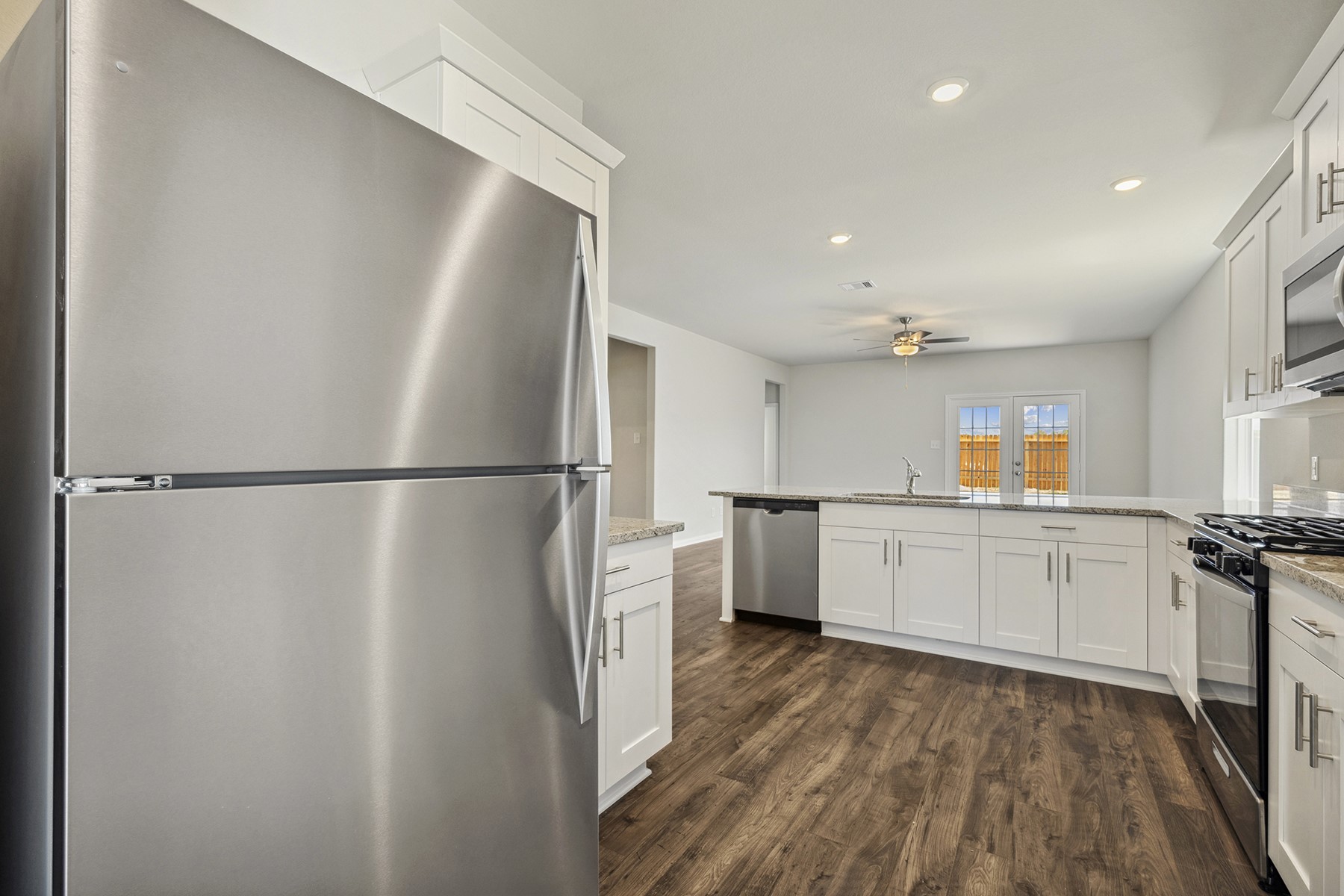 10338 Red Cardinal Drive Cleveland, TX 77328 - Photo 9 of 25 a kitchen with a refrigerator and white cabinets
