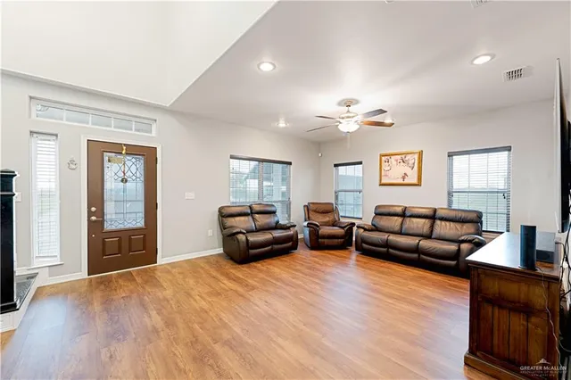 a living room with furniture and a wooden floor