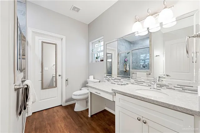 a bathroom with a sink a toilet and a mirror