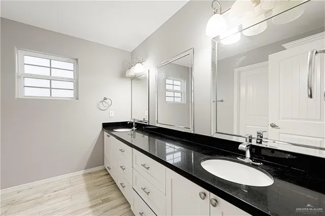 a bathroom with double sink and a mirror