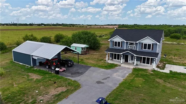 an aerial view of a house with a garden and lake view