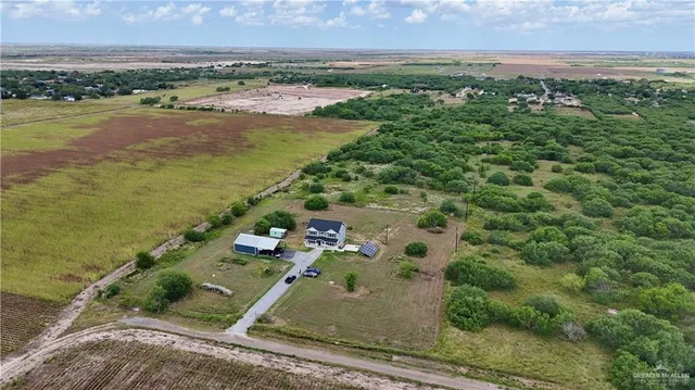 an aerial view of ocean with residential house and outdoor space