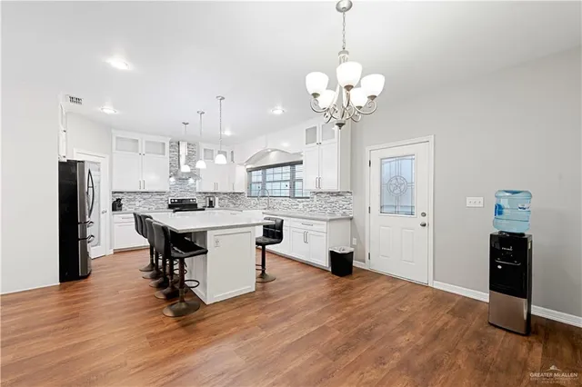 a view of kitchen with refrigerator microwave and wooden floor