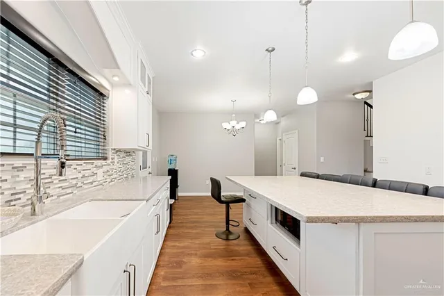 a spacious bathroom with a granite countertop double vanity sink and a bathtub