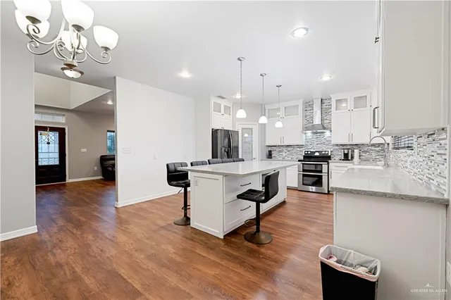 a kitchen with kitchen island stainless steel appliances a dining table and chairs
