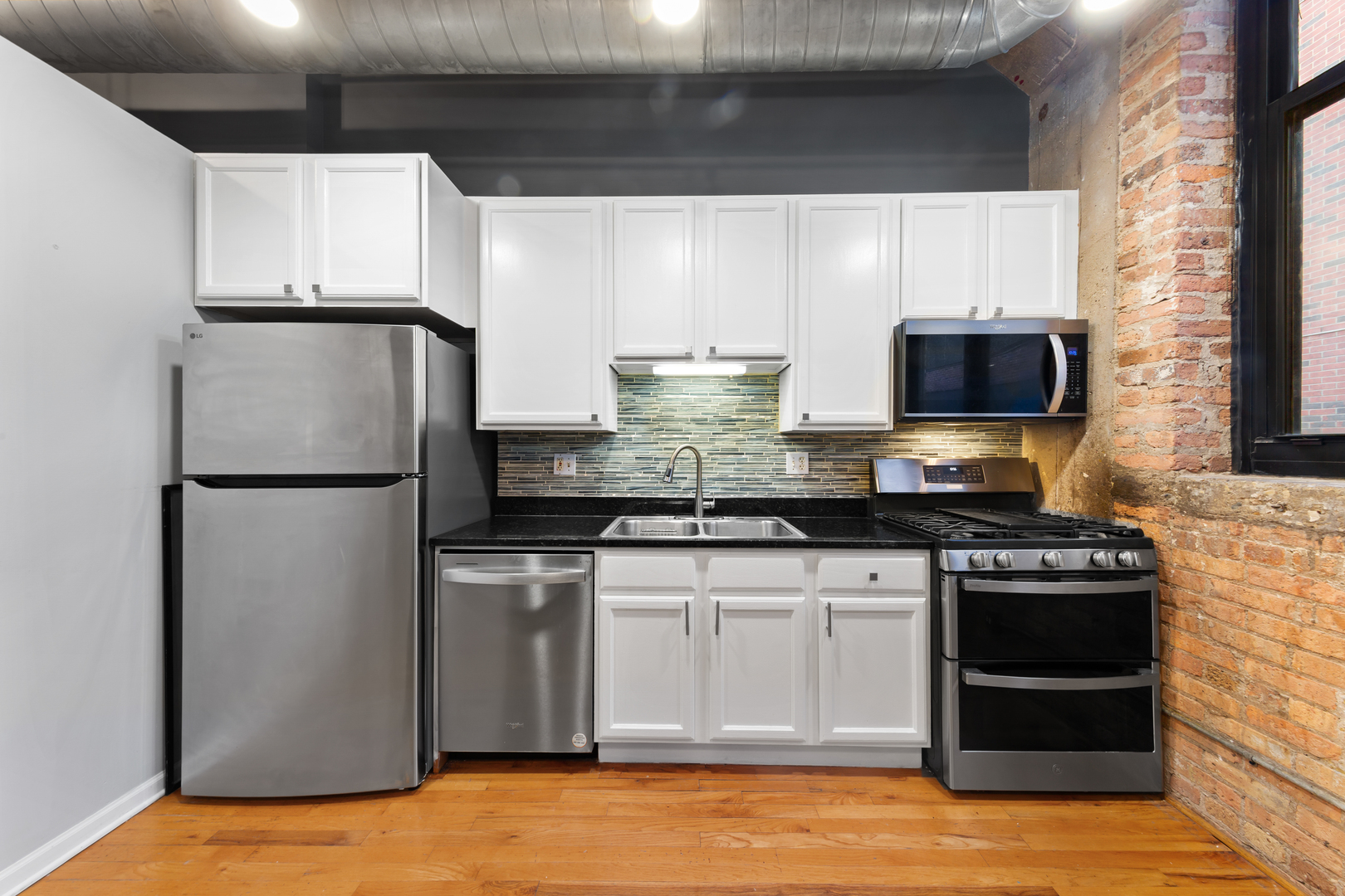 215 North Aberdeen Street, Unit 403A Chicago, IL 60607 - Photo 5 of 22 a kitchen with stainless steel appliances granite countertop a stove a refrigerator and a microwave