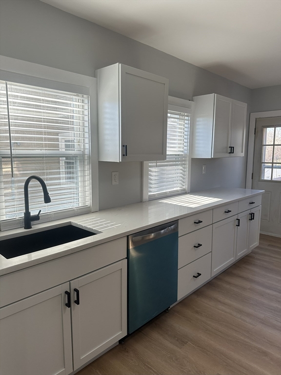 a kitchen with granite countertop white cabinets and a sink