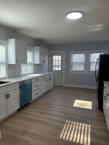 a kitchen with a sink window and cabinets