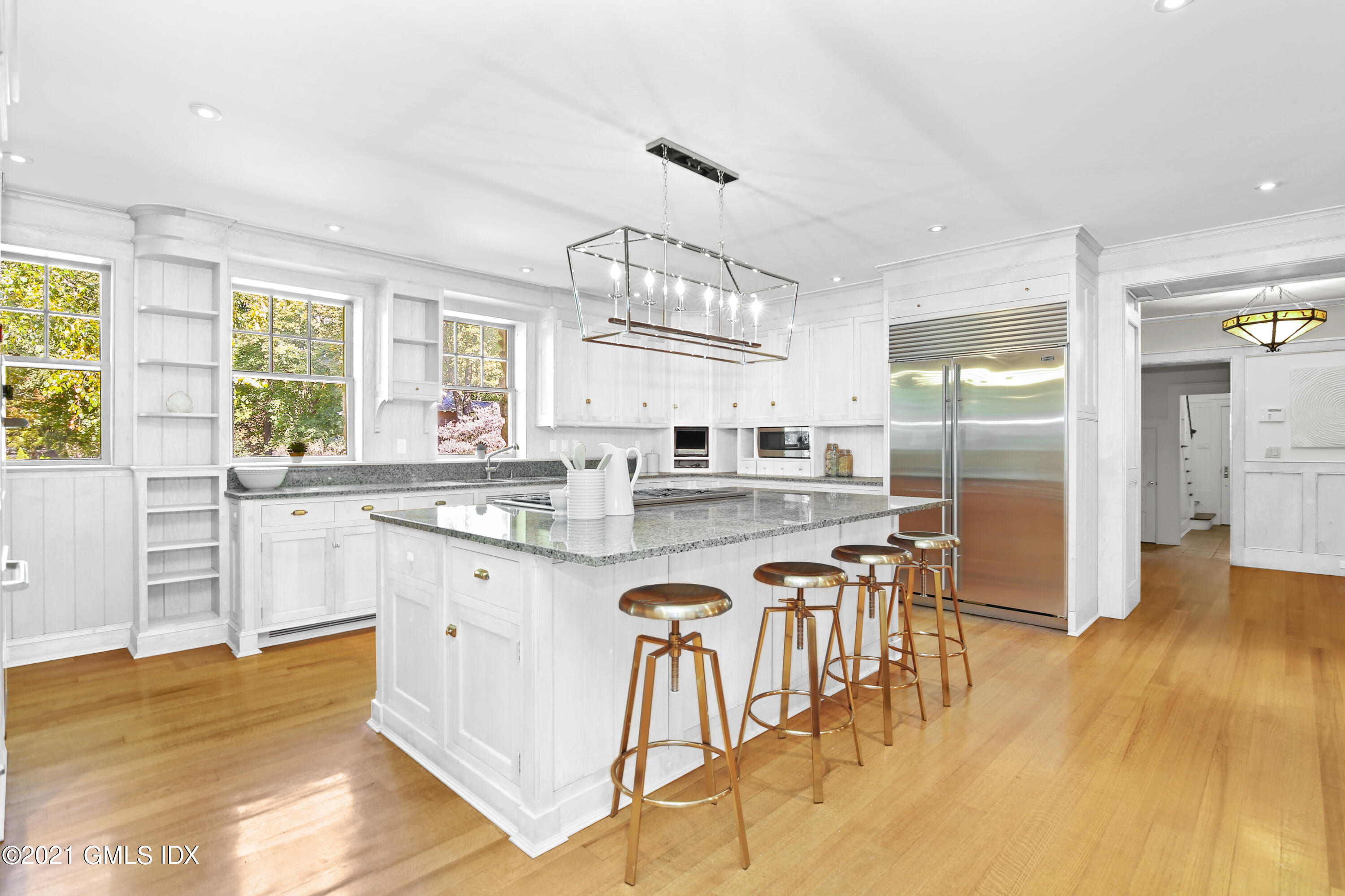 33 Brookridge Drive Greenwich, CT 06830 - Photo 12 of 44 a kitchen with stainless steel appliances granite countertop a stove a refrigerator a sink a dining table and chairs with wooden floor