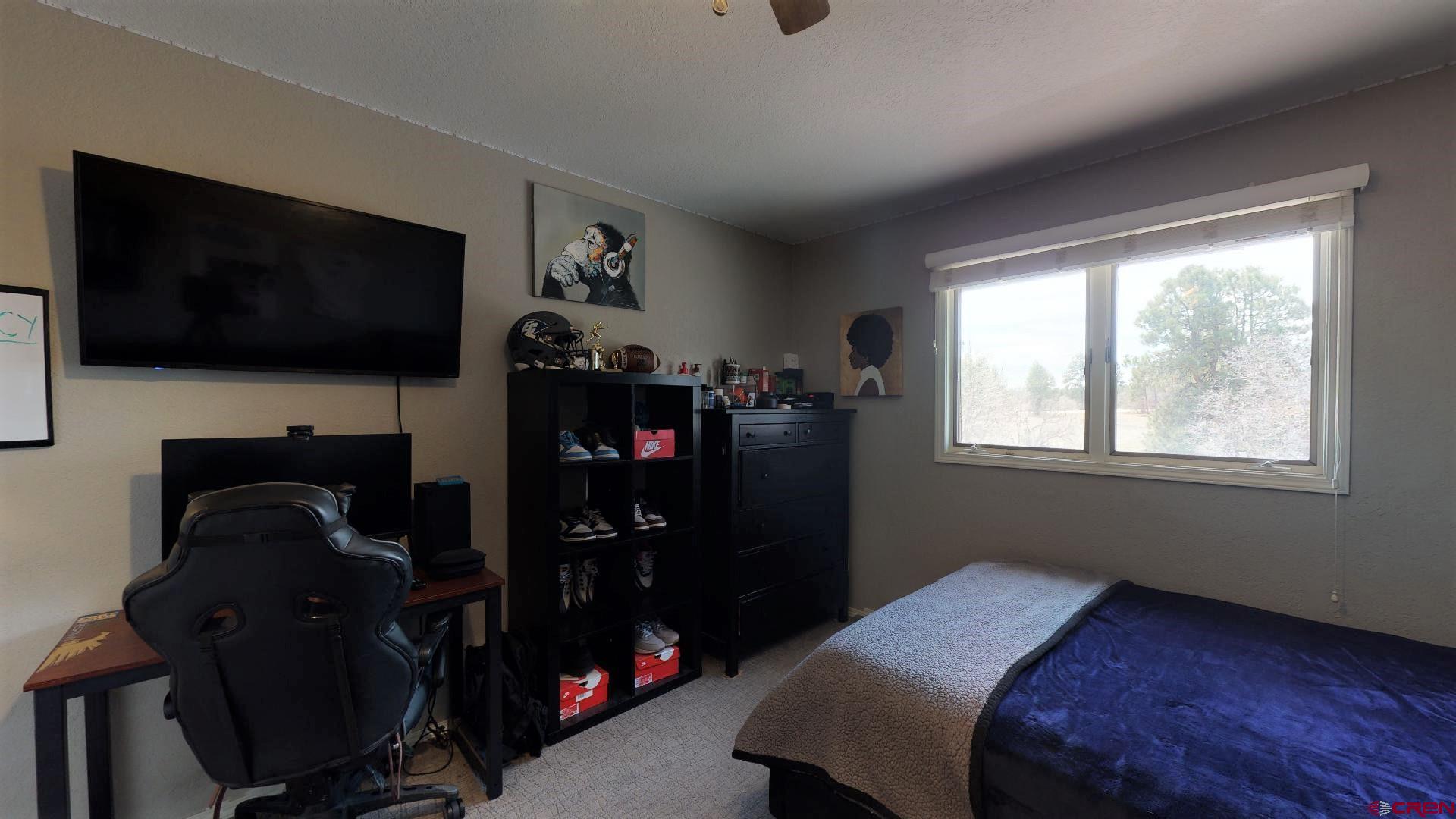 255 Pine Ridge Loop, Unit C5 Durango, CO 81301 - Photo 15 of 32 a bedroom with a bed and a flat tv screen on the dresser