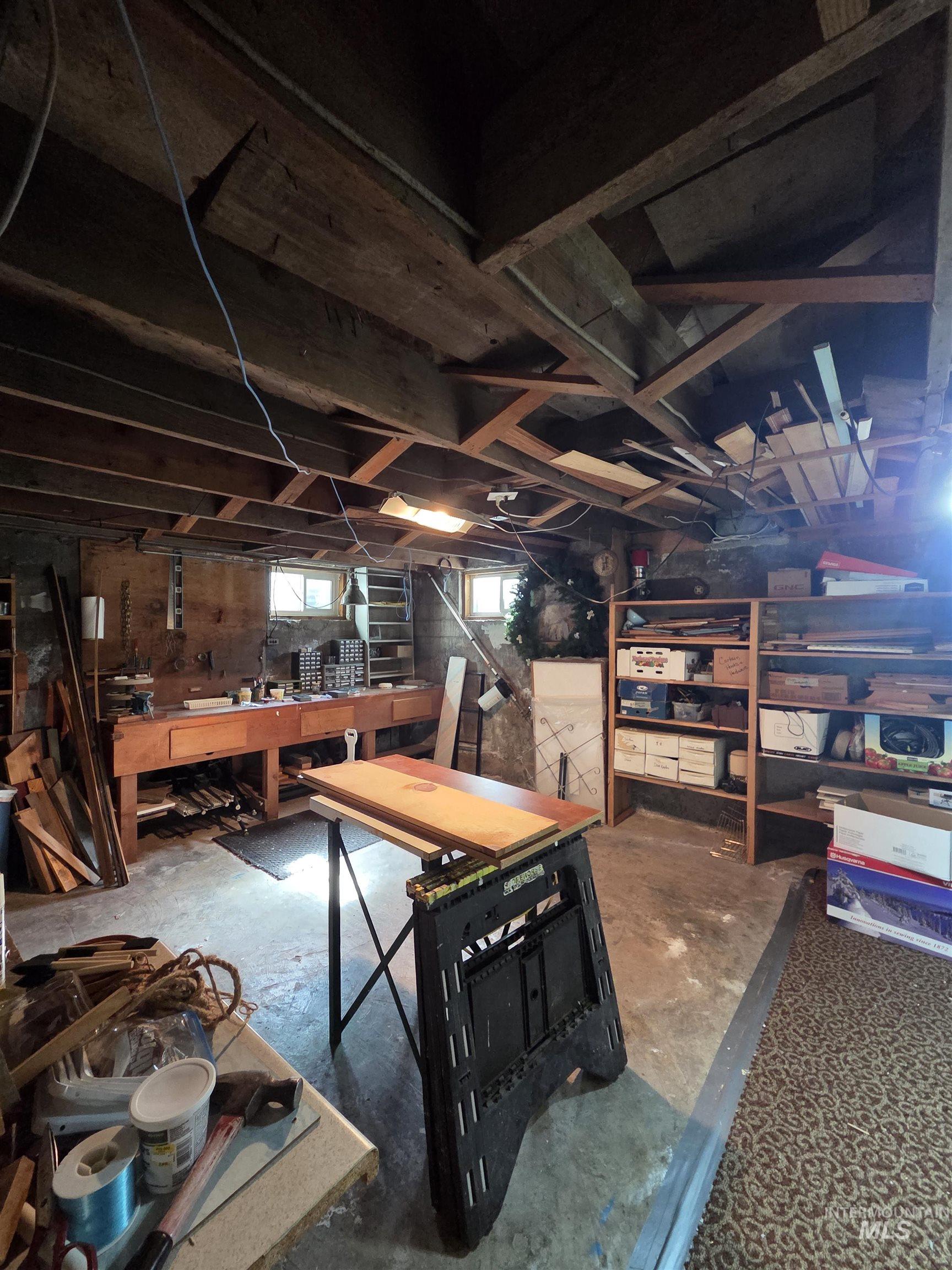 109 South 3rd Street Pomeroy, WA 99347 - Photo 26 of 36 Basement space featuring exposed wood beam ceiling, concrete flooring, and multiple windows