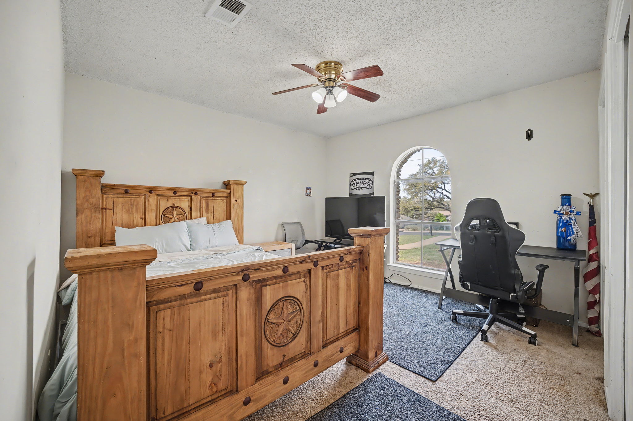 103 Oak Ridge Circle Georgetown, TX 78628 - Photo 16 of 22 Bedroom with a desk, a textured ceiling, light carpet, and a ceiling fan