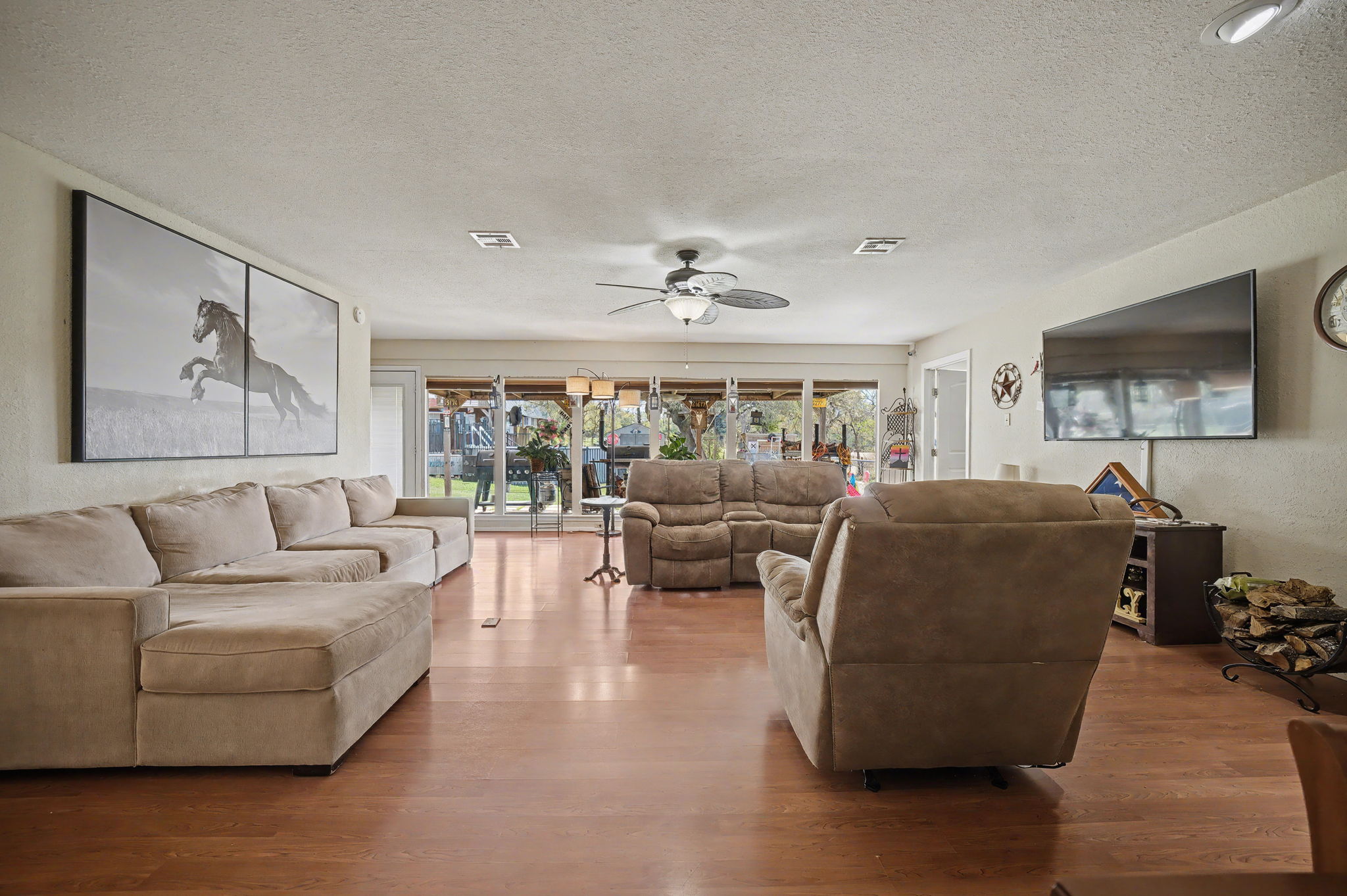 103 Oak Ridge Circle Georgetown, TX 78628 - Photo 8 of 22 Living room featuring a textured ceiling, wood finished floors, ceiling fan, and a textured wall