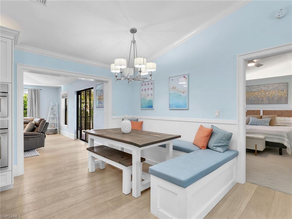 188 Columbus Way Marco Island, FL 34145 - Photo 10 of 38 Dining area featuring ornamental molding, wainscoting, light wood-type flooring, and breakfast area