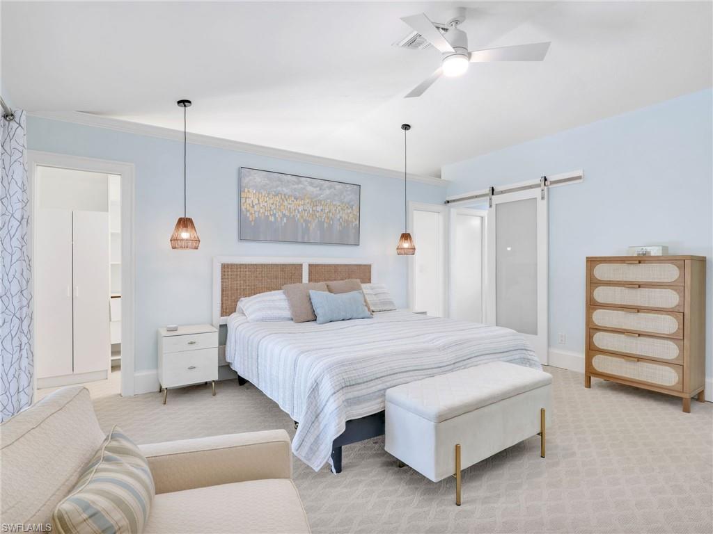 188 Columbus Way Marco Island, FL 34145 - Photo 15 of 38 Carpeted bedroom featuring ensuite bathroom, a barn door, ceiling fan, and crown molding