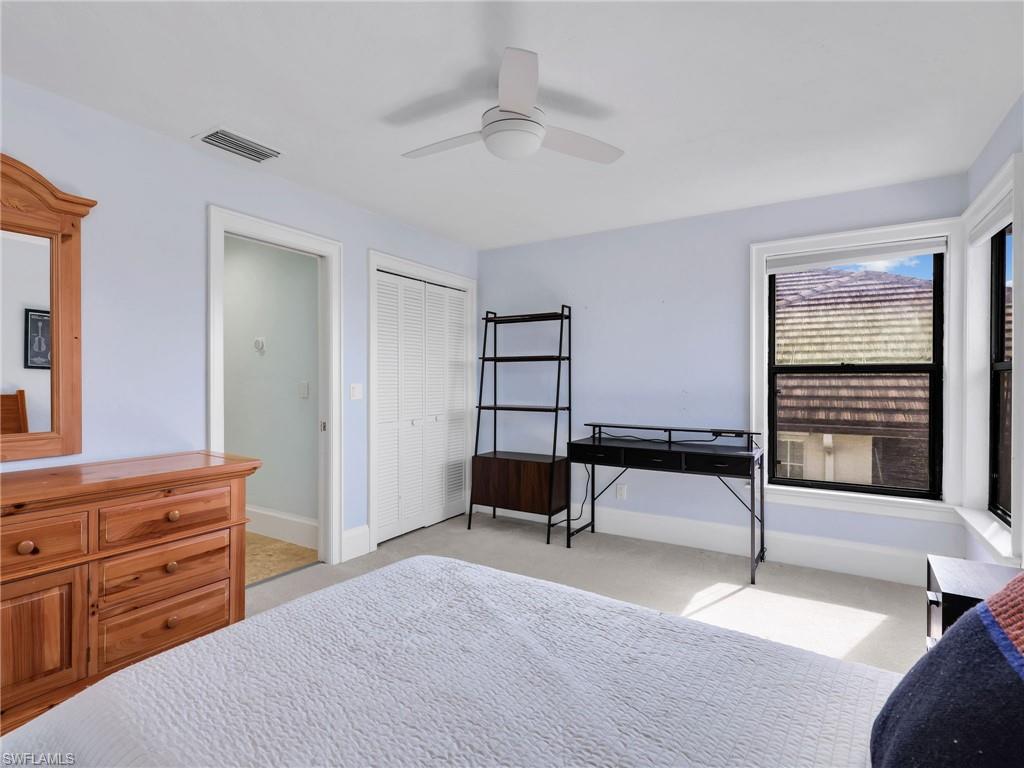 188 Columbus Way Marco Island, FL 34145 - Photo 21 of 38 Bedroom with light colored carpet, a ceiling fan, and a closet