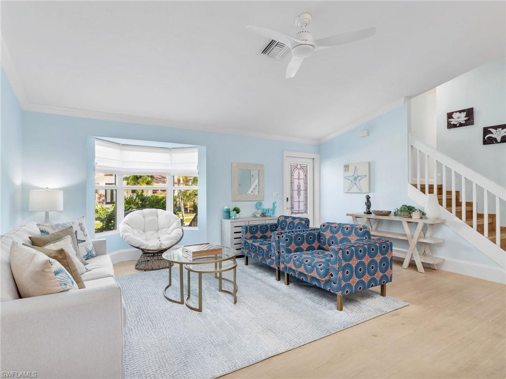 188 Columbus Way Marco Island, FL 34145 - Photo 5 of 38 Living room featuring stairway, wood finished floors, crown molding, and a ceiling fan