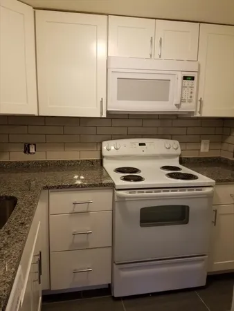 a stove top oven sitting inside of a kitchen