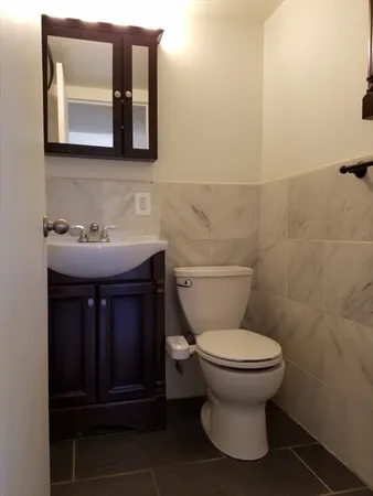 a bathroom with a toilet sink and mirror