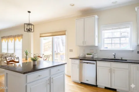 a kitchen with granite countertop white cabinets and white appliances