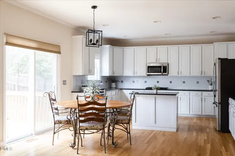 a kitchen with granite countertop white cabinets sink and window