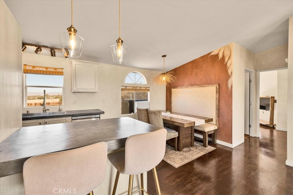 60707 Sonora Road Joshua Tree, CA 92252 - Photo 19 of 48 a kitchen with stainless steel appliances granite countertop a sink a stove and chairs with wooden floor