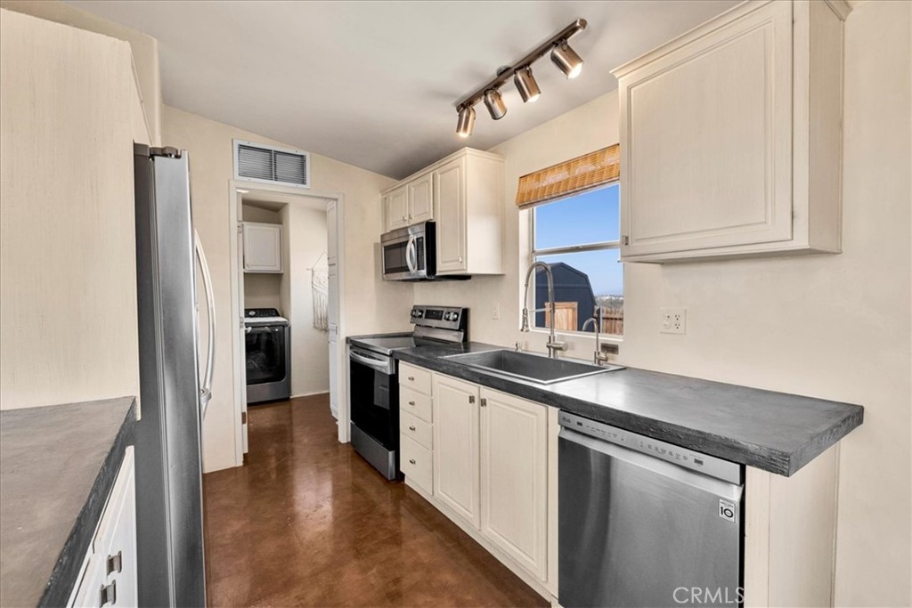 60707 Sonora Road Joshua Tree, CA 92252 - Photo 21 of 48 a kitchen with stainless steel appliances granite countertop a sink stove and refrigerator